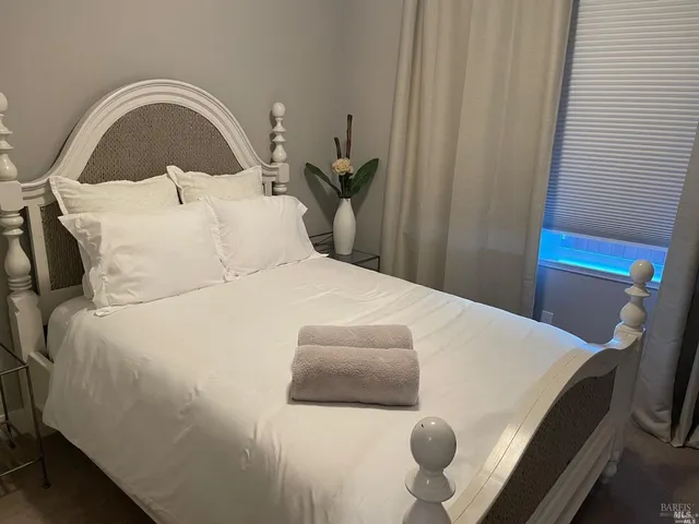 a bed sitting in a bedroom next to a window