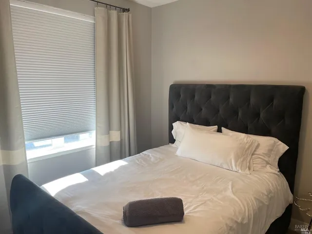 a bed sitting in a bedroom next to a window