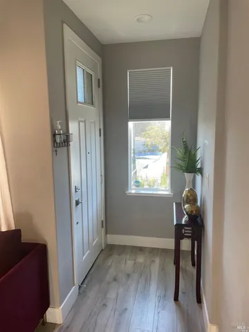 a view of a hallway to a livingroom with furniture and a window