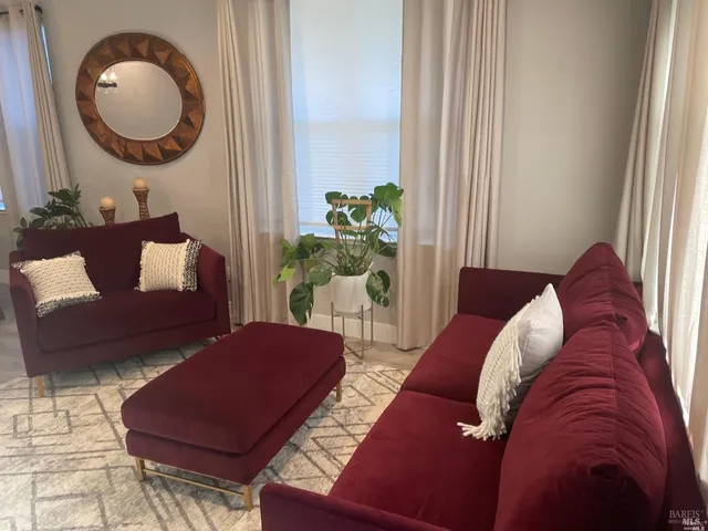 a living room with furniture and a mirror