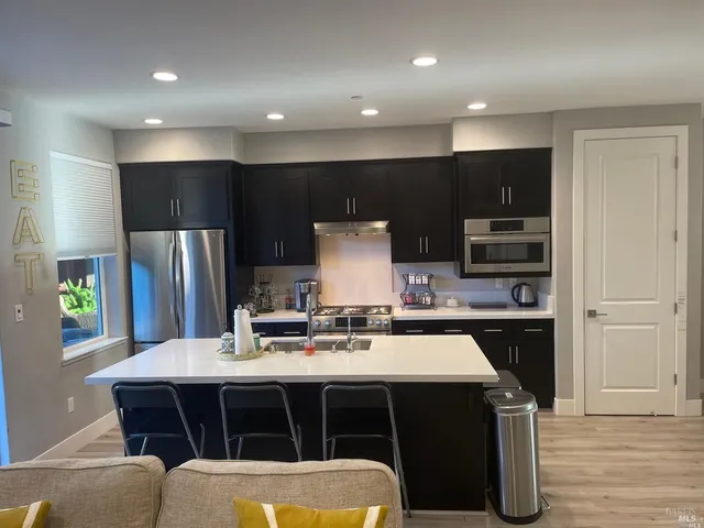 a kitchen with a table chairs refrigerator and microwave