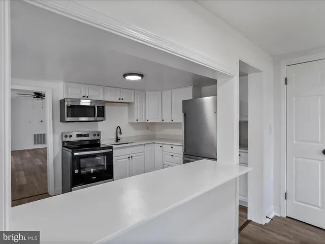 a kitchen with stainless steel appliances granite countertop a refrigerator stove top oven and sink