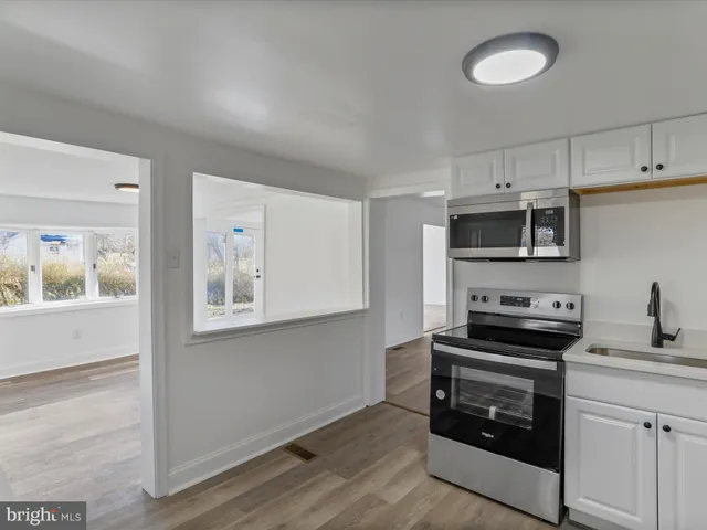 a kitchen with stainless steel appliances a stove microwave and sink