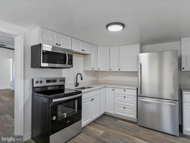 a kitchen with a refrigerator stove and white cabinets