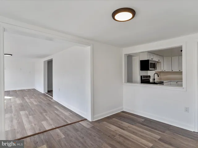 a view of a livingroom with wooden floor and a ceiling fan