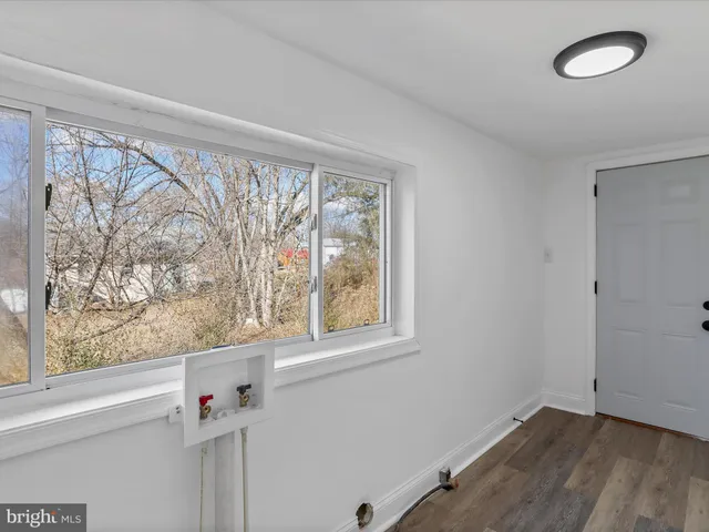 a view of a room that has a window and wooden floor