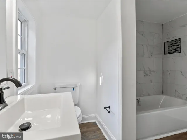a bathroom with a tub a sink and a large window