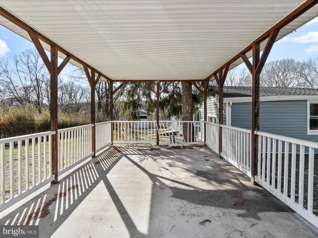 a view of backyard with large trees and wooden fence