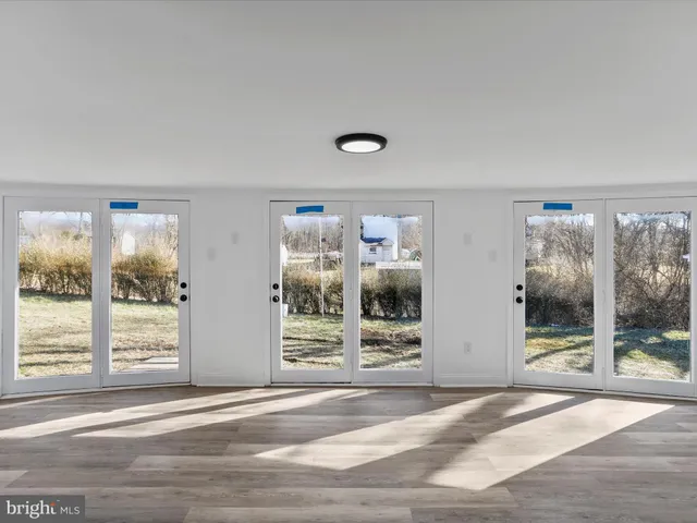 a view of a livingroom with wooden floor and windows