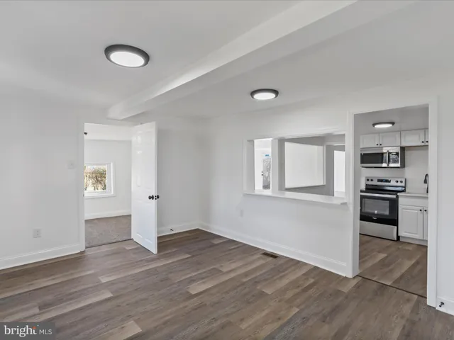 a view of a kitchen with a sink stove cabinets and empty room