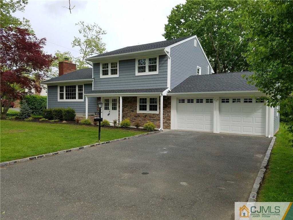 1103 Sawmill Road Mountainside, NJ 07092 - Photo 1 of 25 a front view of a house with a yard and garage