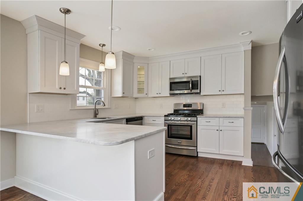 1103 Sawmill Road Mountainside, NJ 07092 - Photo 3 of 25 a kitchen with stainless steel appliances granite countertop a stove a sink and a refrigerator