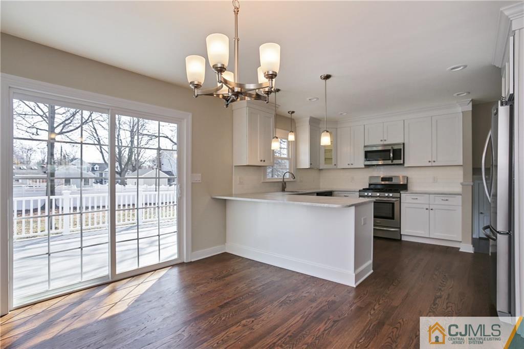 1103 Sawmill Road Mountainside, NJ 07092 - Photo 4 of 25 a kitchen with stainless steel appliances granite countertop a refrigerator a sink dishwasher a stove and white cabinets with wooden floor