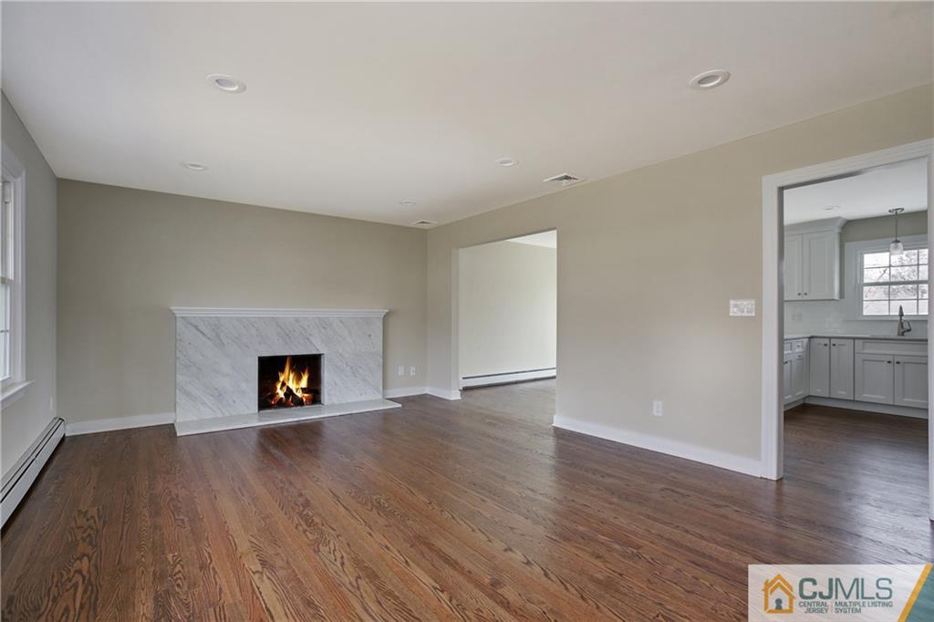 1103 Sawmill Road Mountainside, NJ 07092 - Photo 8 of 25 an empty room with wooden floor a fireplace and windows