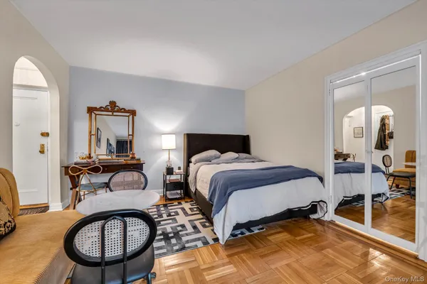 a bedroom with a bed a mirror and lamp