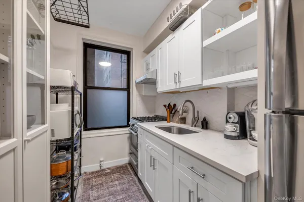 a kitchen with stainless steel appliances granite countertop a sink refrigerator and cabinets