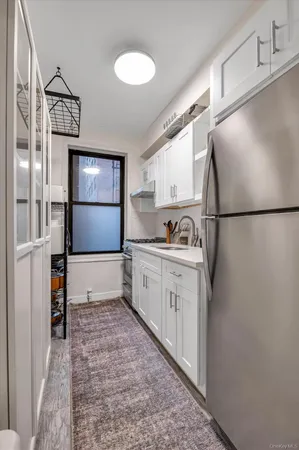 a kitchen with a refrigerator a stove and cabinets