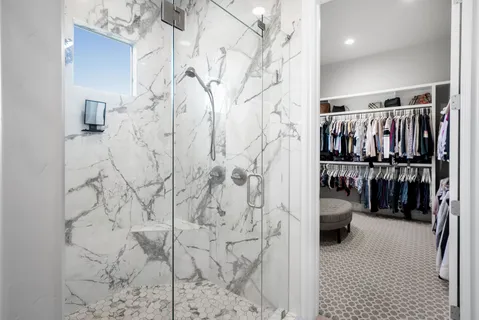 a view of walk in closet with clothes and shoes