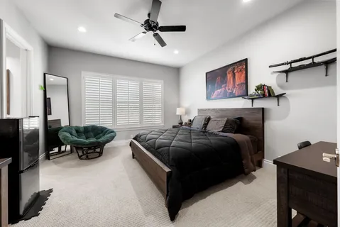 a spacious bedroom with a bed a couch and large window