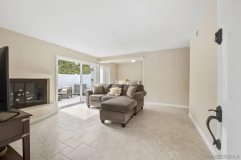 a living room with furniture a fireplace and a floor to ceiling window