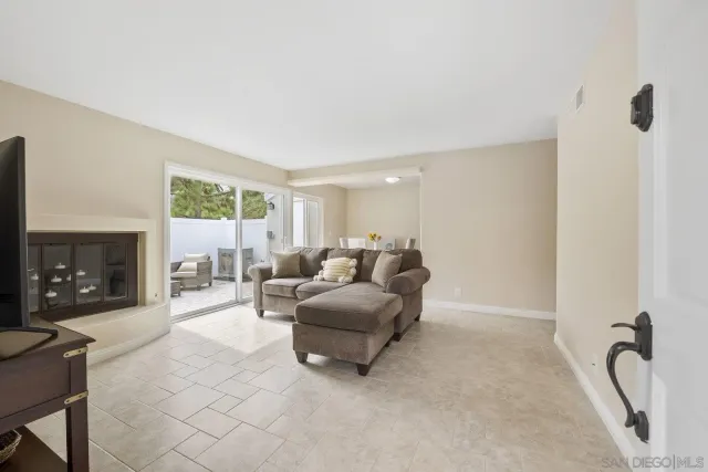 a living room with furniture a fireplace and a floor to ceiling window