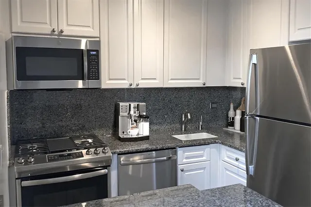 a kitchen with stainless steel appliances a stove a microwave and a refrigerator