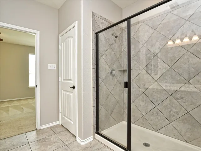 a bathroom with a shower and a glass door