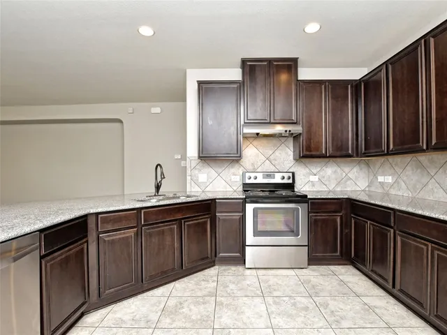 a kitchen with stainless steel appliances granite countertop wooden cabinets a sink and dishwasher