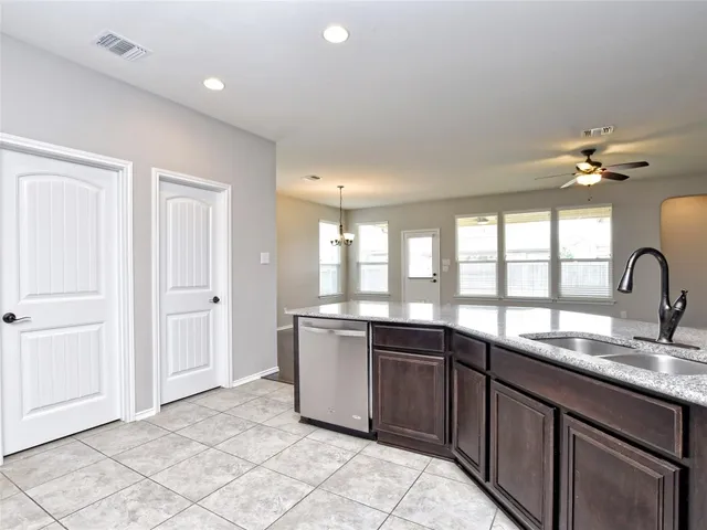 a large kitchen with kitchen island granite countertop a sink and cabinets