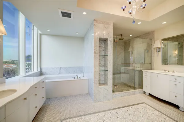 a bathroom with a tub a sink shower and mirror