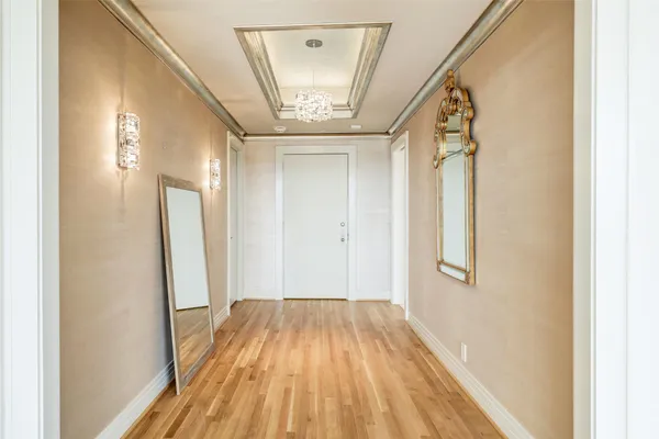 a view of a hallway with wooden floor and staircase