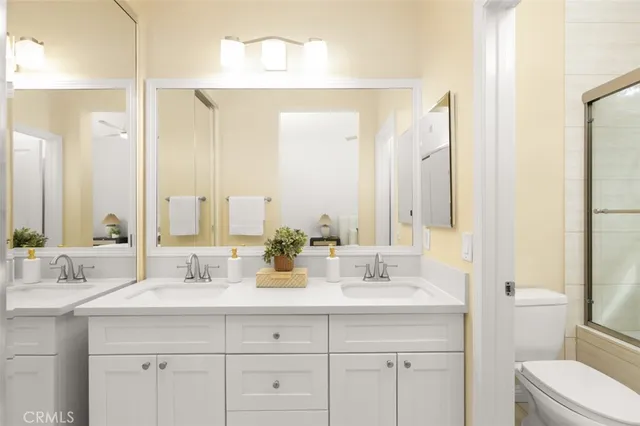 a bathroom with double sink and a mirror