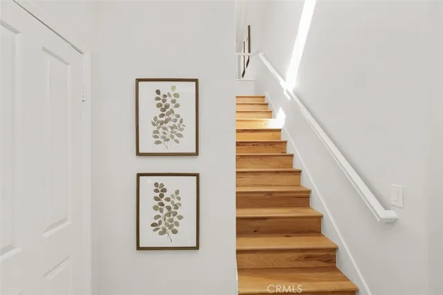 a view of staircase with wooden floor and white walls