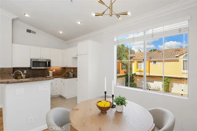 a kitchen with stainless steel appliances granite countertop a stove a sink a dining table and chairs