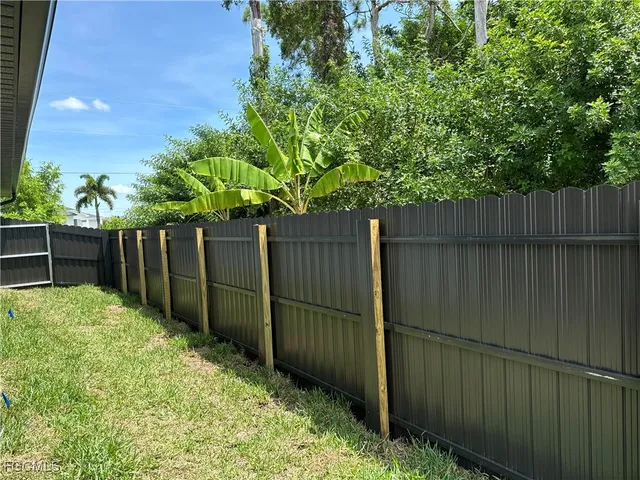 a view of backyard with wooden fence