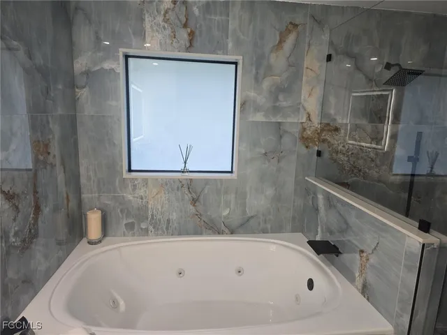 a white bath tub sitting next to a shower