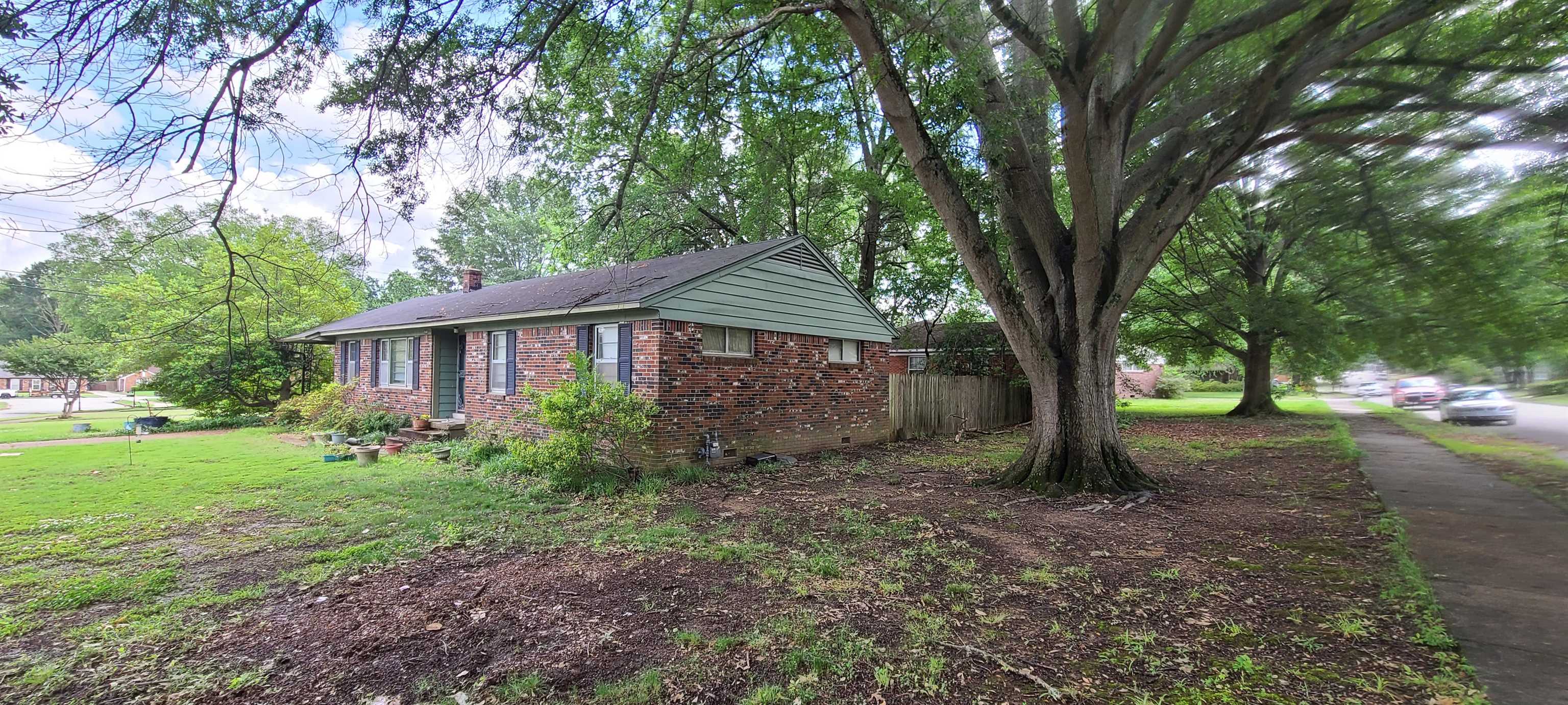 5569 Milam Road Memphis, TN 38120 - Photo 32 of 37 a view of a house with yard and a tree
