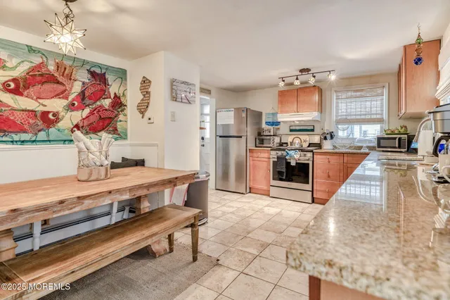 a large kitchen with stainless steel appliances granite countertop a stove a sink dishwasher and cabinets with wooden floor