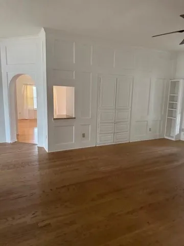 a view of an empty room with window and wooden floor