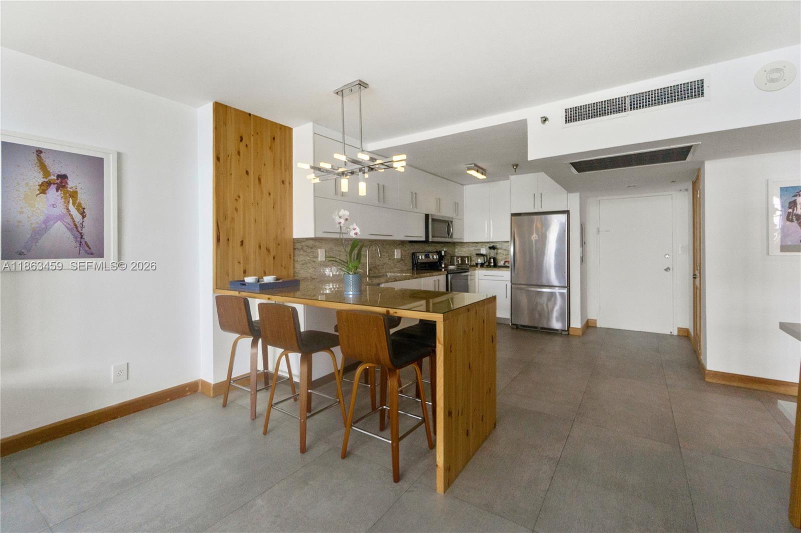 100 Lincoln Road, Unit 1635 Miami Beach, FL 33139 - Photo 5 of 38 a kitchen with a refrigerator and a table
