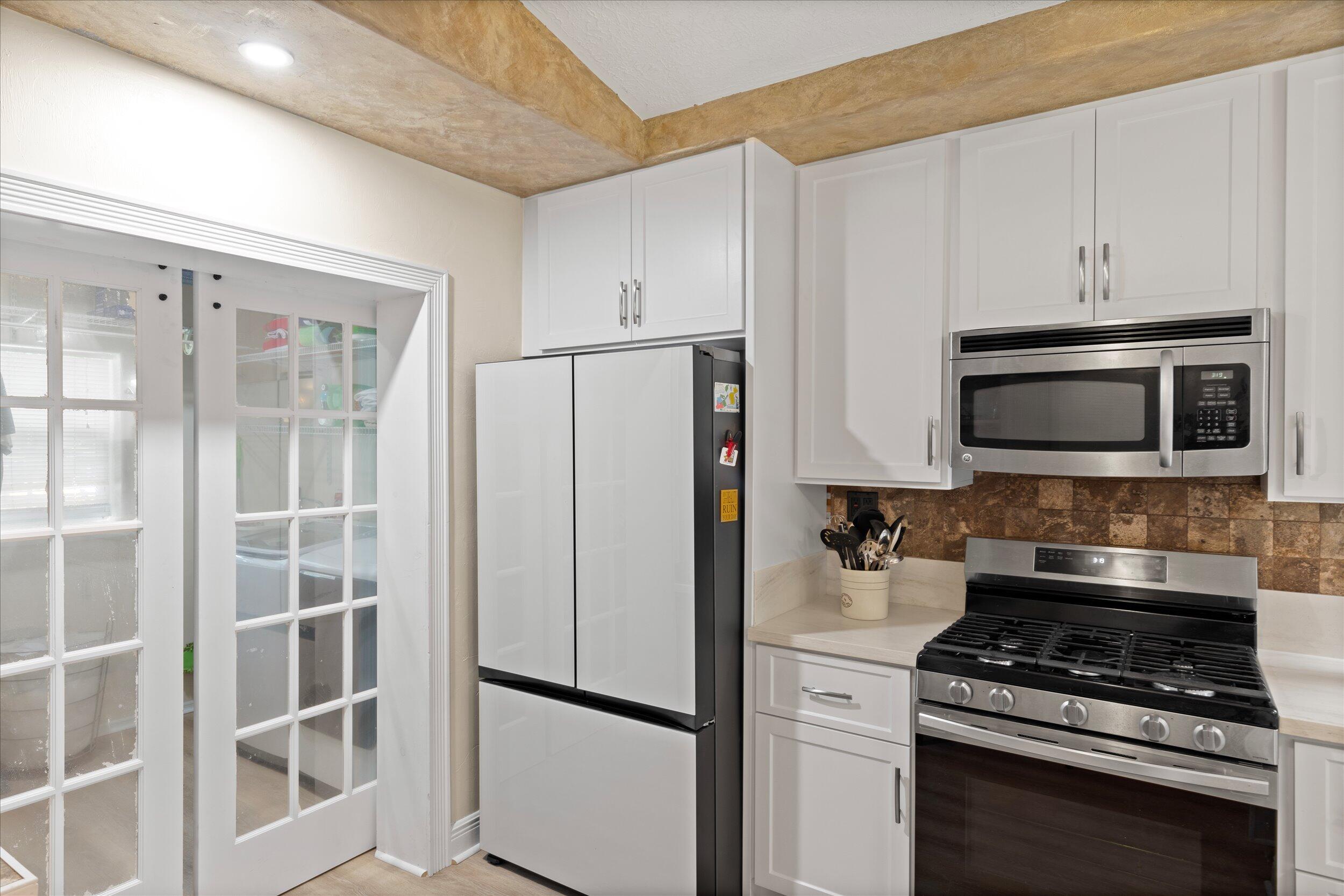 1320 6th Street Key West, FL 33040 - Photo 26 of 61 a kitchen with stainless steel appliances a refrigerator stove and microwave