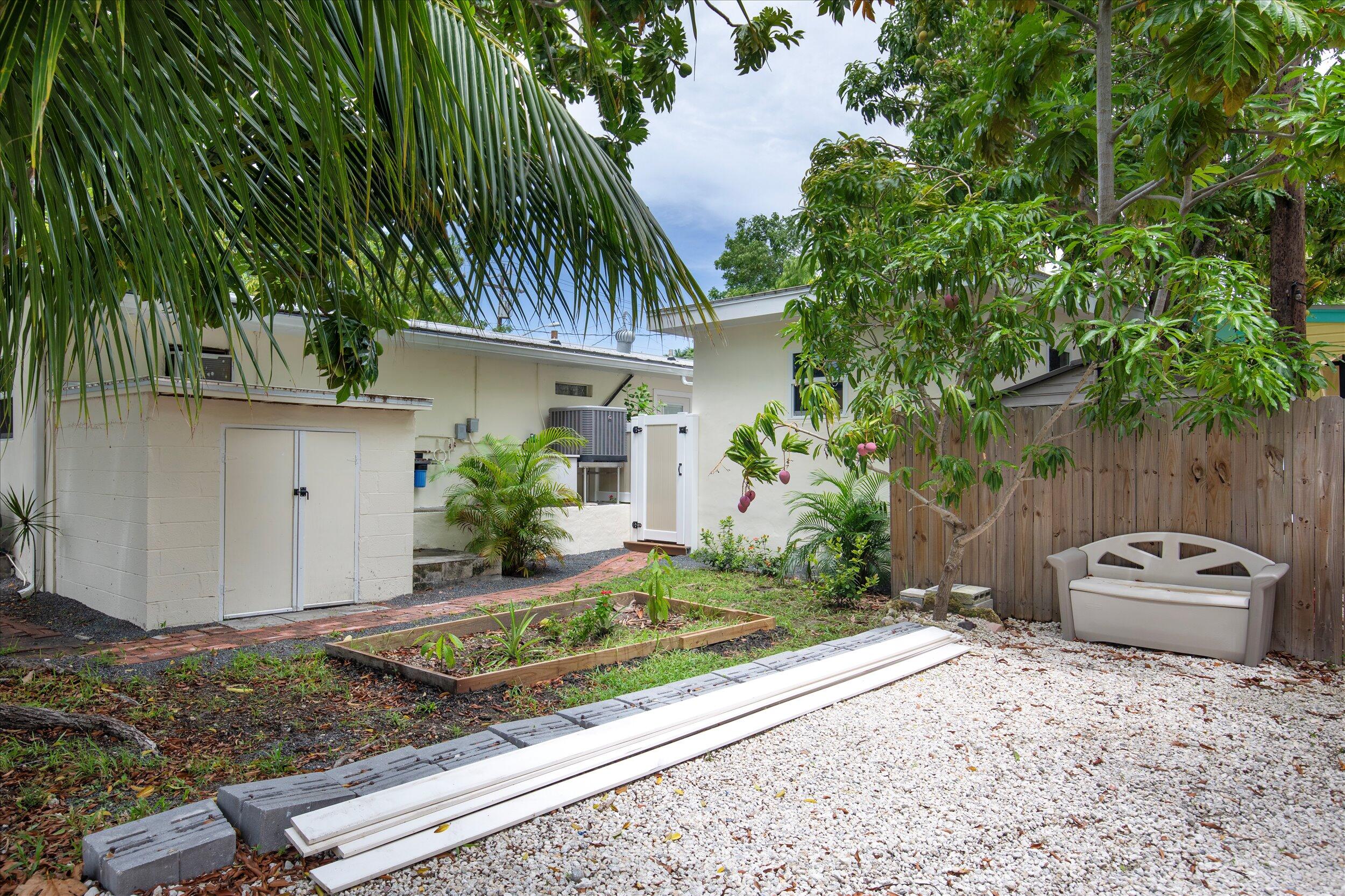 1320 6th Street Key West, FL 33040 - Photo 55 of 61 a backyard of a house with potted plants and large tree
