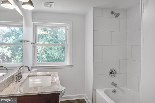 a bathroom with a sink a bathtub and window