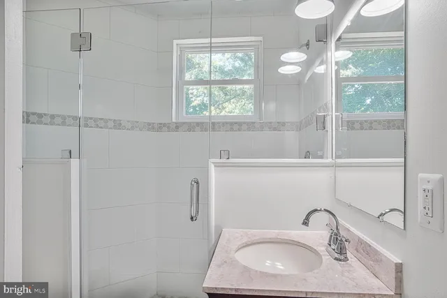 a bathroom with a sink a window and a mirror