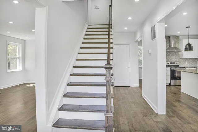 a view of entryway with wooden floor and kitchen