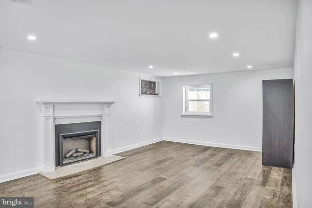 an empty room with a fireplace and wooden floor