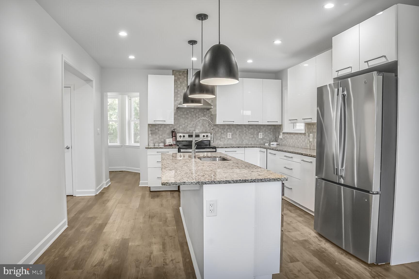 4515 Old Branch Avenue Temple Hills, MD 20748 - Photo 6 of 21 a kitchen with stainless steel appliances granite countertop a refrigerator a sink dishwasher a stove and white cabinets with wooden floor