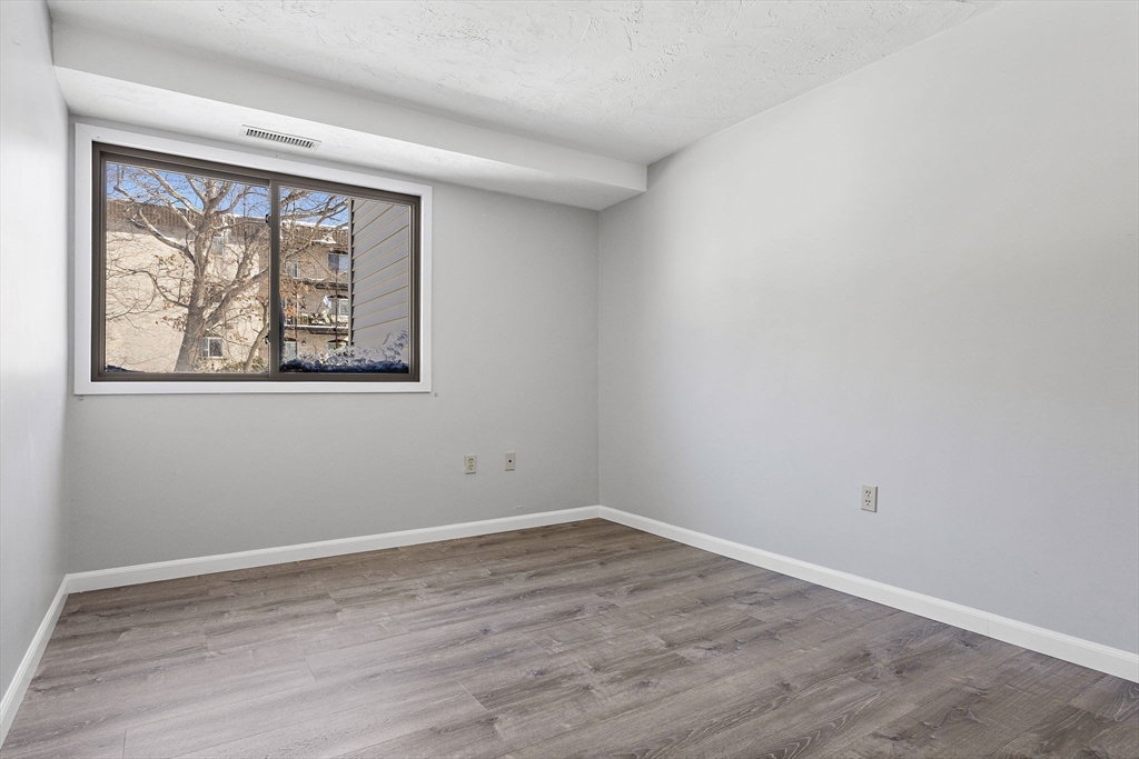 189 Littleton Road, Unit 10 Chelmsford, MA 01824 - Photo 12 of 19 wooden floor in an empty room with a window
