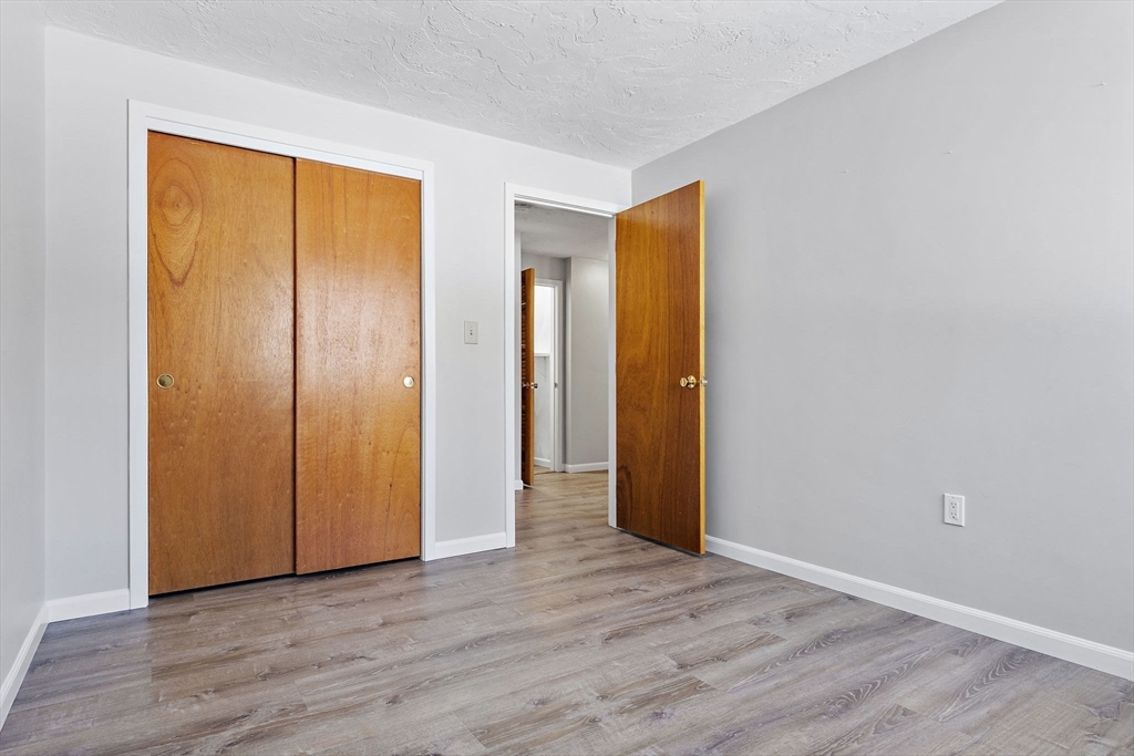 189 Littleton Road, Unit 10 Chelmsford, MA 01824 - Photo 13 of 19 a view of an empty room with wooden floor and closet
