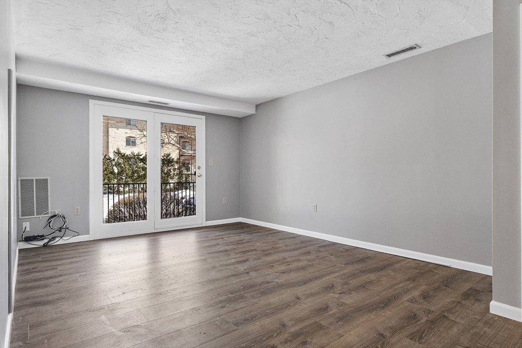 189 Littleton Road, Unit 10 Chelmsford, MA 01824 - Photo 6 of 19 a view of an empty room with wooden floor and a window